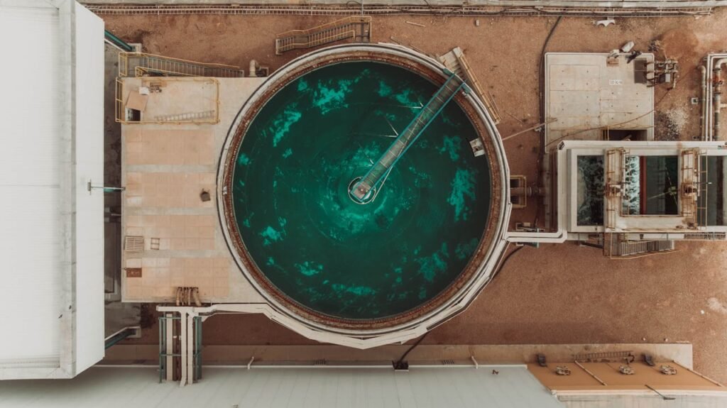 Drone view of a large circular water treatment tank at an industrial facility.