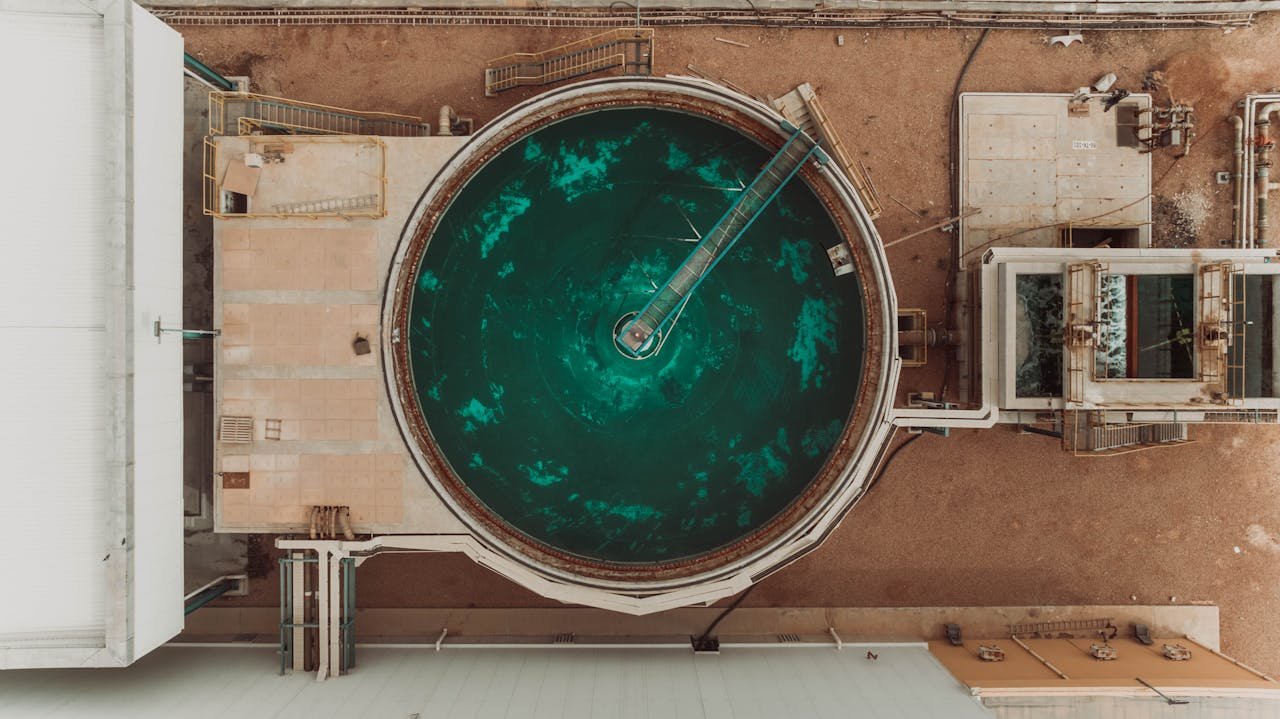 Drone view of a large circular water treatment tank at an industrial facility.